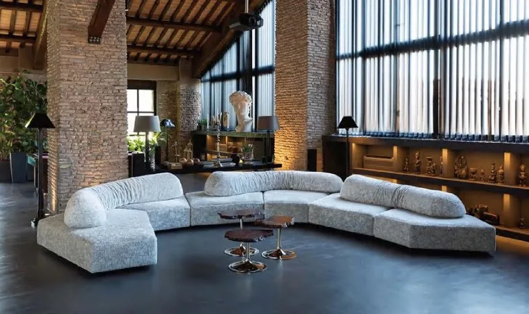 Living room with a curved grey sectional sofa and tiered coffee tables