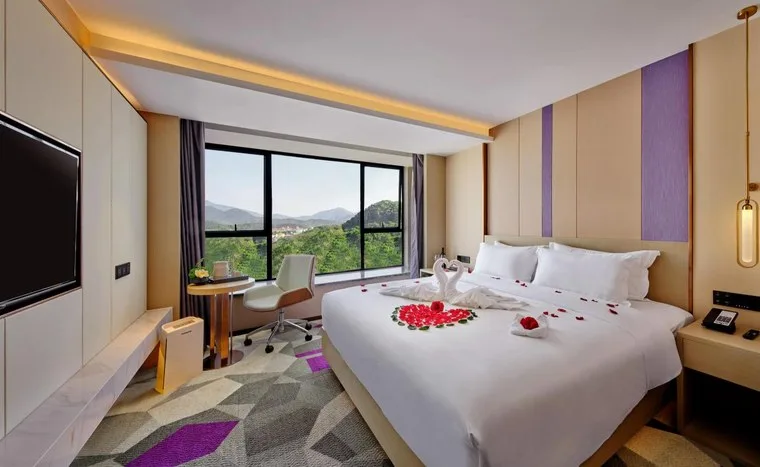 Hotel guest room with a made bed and a mountain view